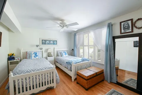 a spacious bedroom with a bed a wall painting and a potted plant
