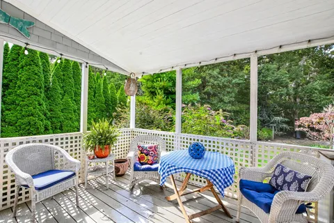 a view of a chair and table in backyard of the house