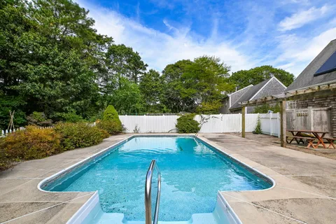 a front view of a house with a yard and tree s