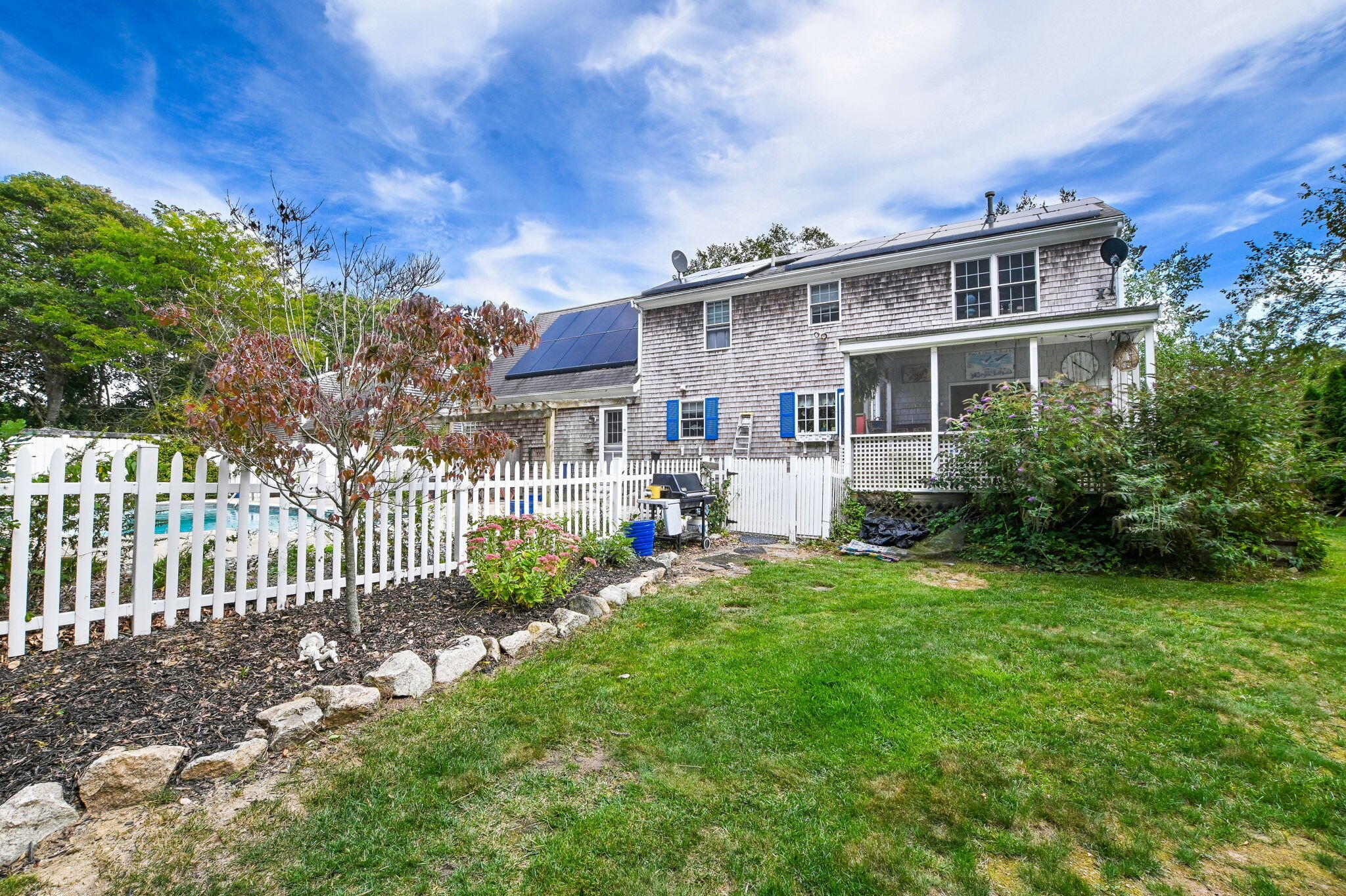 25 Harris Hill Road East Falmouth, MA 02536 - Photo 3 of 37 a front view of a house with a yard table and chairs