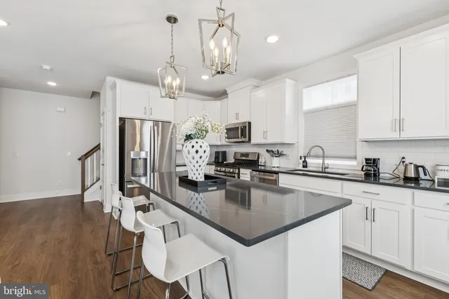 a kitchen with stainless steel appliances granite countertop a sink a stove top oven a counter space and cabinets