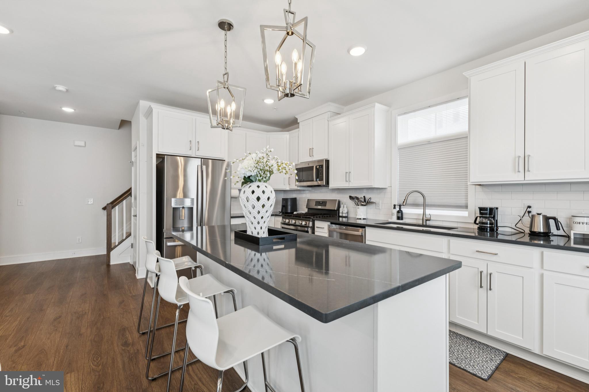 42597 Nubbins Terrace Ashburn, VA 20147 - Photo 16 of 40 a kitchen with stainless steel appliances granite countertop a sink a stove top oven a counter space and cabinets