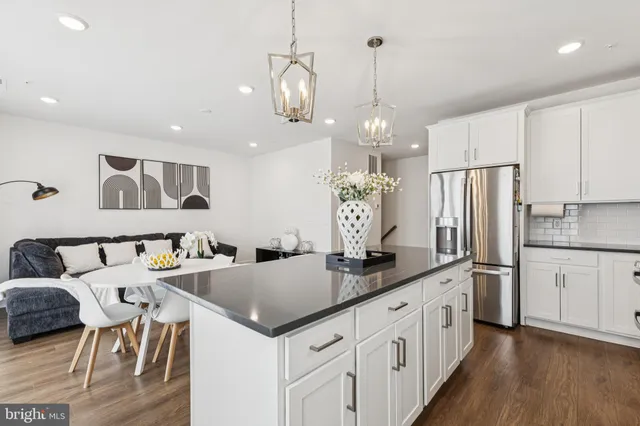 a kitchen with stainless steel appliances granite countertop a kitchen island a stove a table and chairs