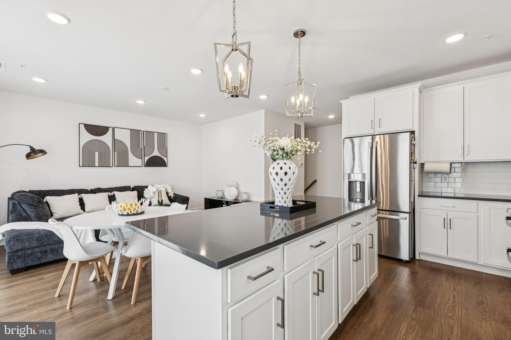 42597 Nubbins Terrace Ashburn, VA 20147 - Photo 17 of 40 a kitchen with stainless steel appliances granite countertop a kitchen island a stove a table and chairs