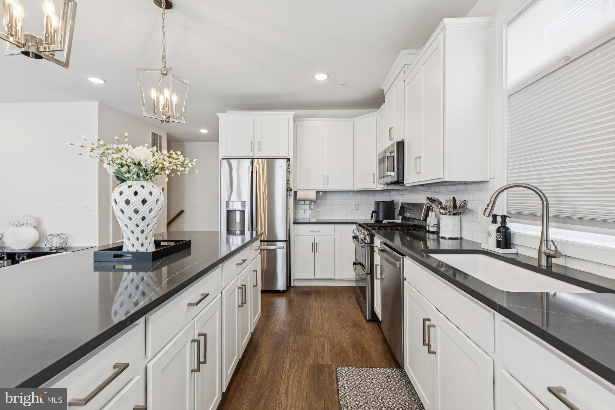 42597 Nubbins Terrace Ashburn, VA 20147 - Photo 19 of 40 a kitchen with granite countertop a sink stainless steel appliances and cabinets
