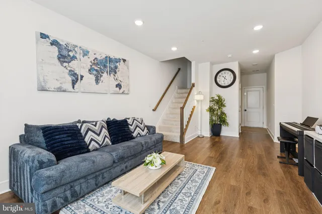 a living room with furniture and a wooden floor