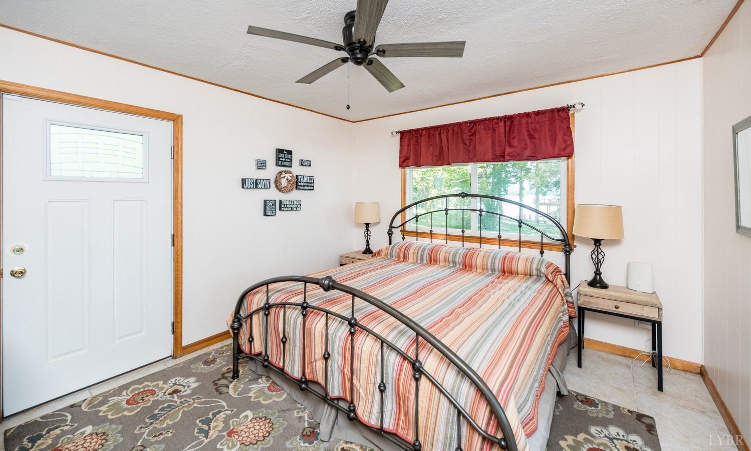 311 Anthony Home Road Huddleston, VA 24104 - Photo 31 of 70 a bedroom with a bed a chandelier and a window