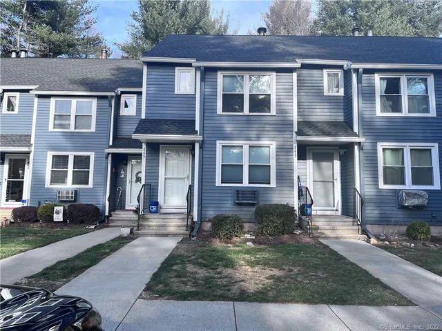 front view of a brick house with a yard
