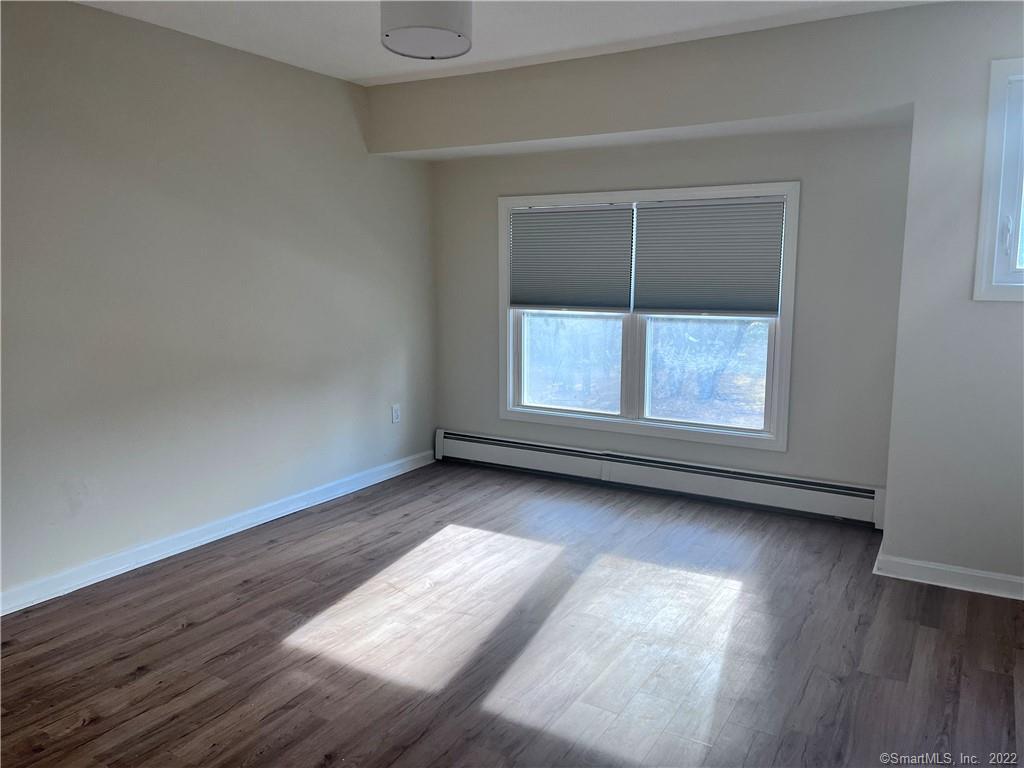 745 Greens Loop, Unit 745 Cheshire, CT 06410 - Photo 17 of 22 an empty room with wooden floor and windows
