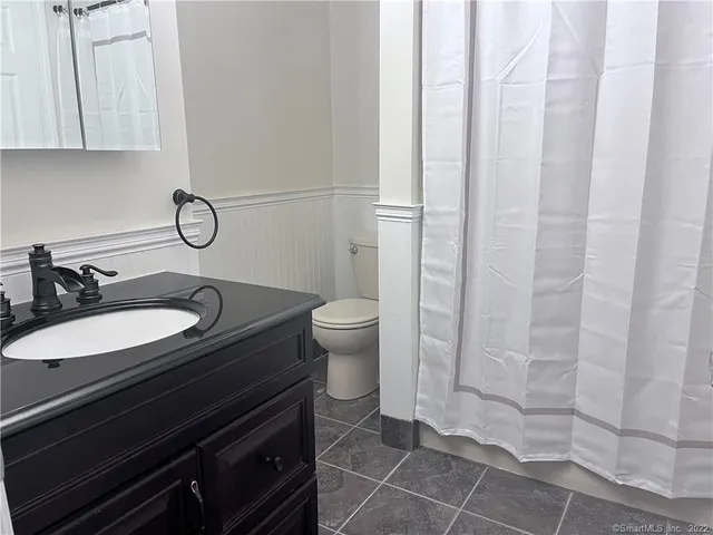 a bathroom with a sink a toilet and a mirror