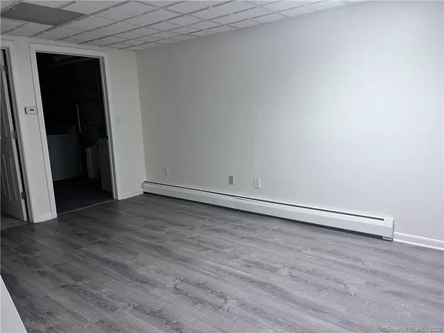 a view of an empty room with wooden floor and closet