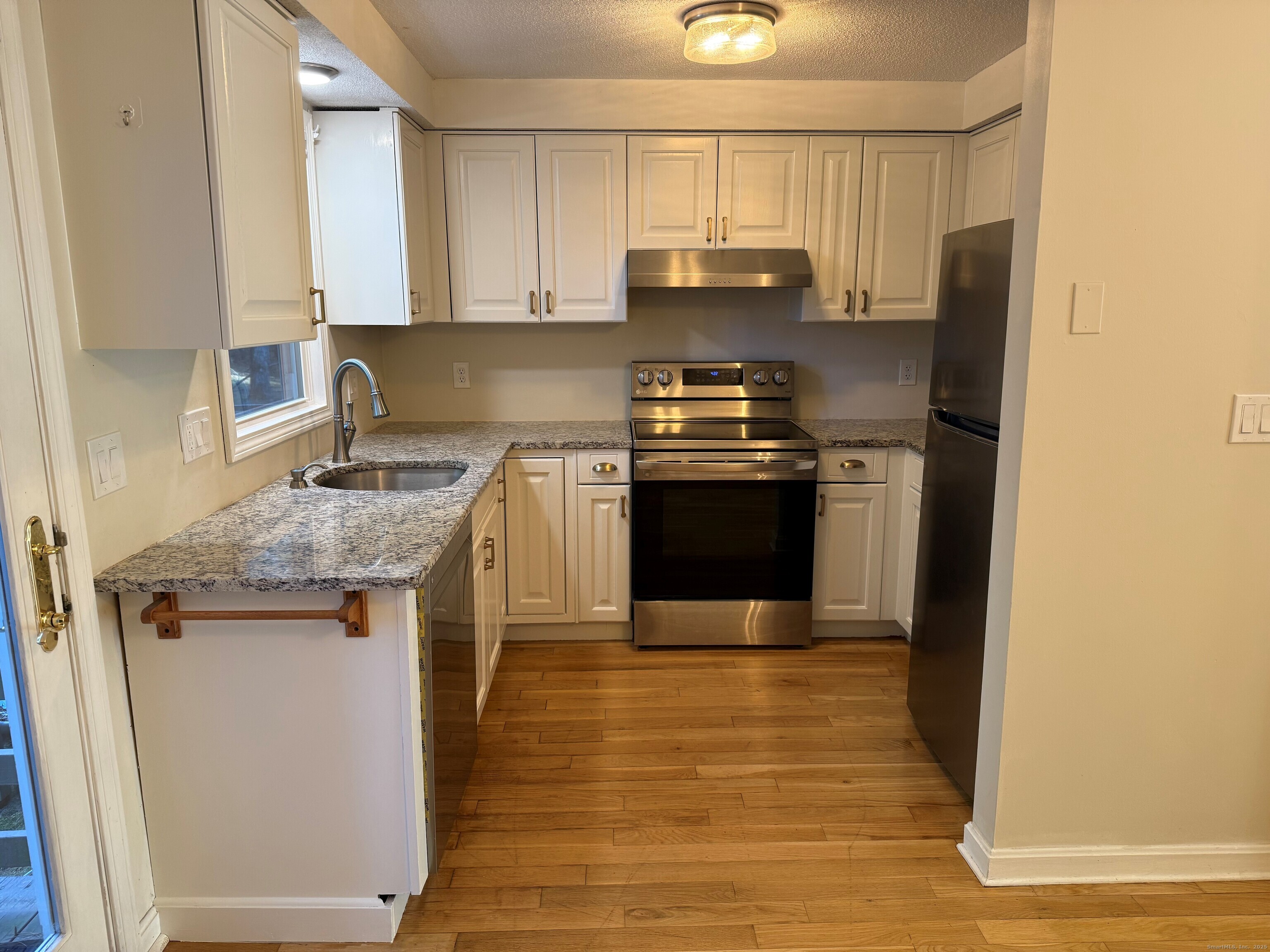 745 Greens Loop, Unit 745 Cheshire, CT 06410 - Photo 7 of 22 a kitchen with stainless steel appliances granite countertop a stove a sink and a refrigerator
