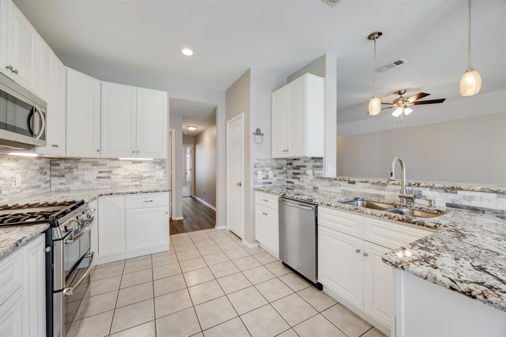 2271 Fieldcrest Drive Rockwall, TX 75032 - Photo 11 of 24 a kitchen with a sink stove and cabinets