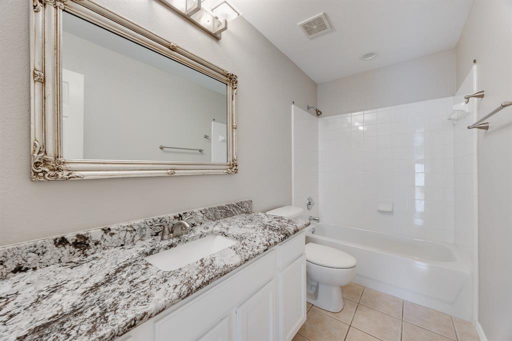2271 Fieldcrest Drive Rockwall, TX 75032 - Photo 14 of 24 a bathroom with a granite countertop sink a toilet and a shower