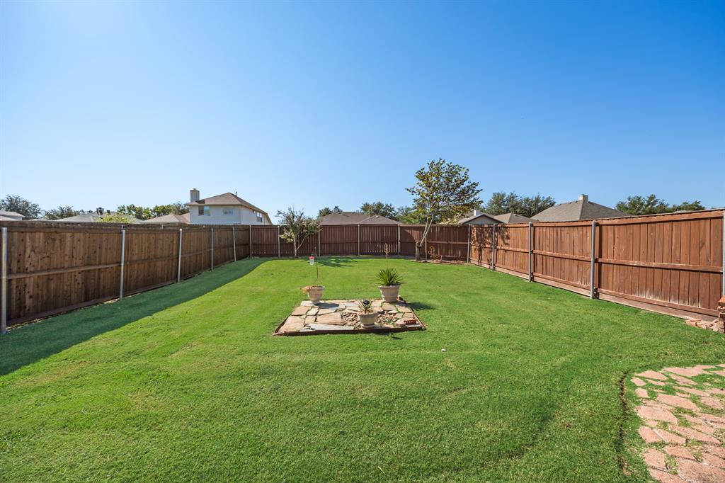 2271 Fieldcrest Drive Rockwall, TX 75032 - Photo 22 of 24 a view of a backyard with couches plants and wooden fence
