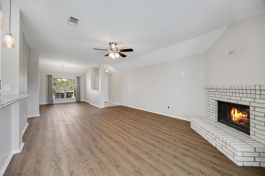2271 Fieldcrest Drive Rockwall, TX 75032 - Photo 7 of 24 a view of an empty room with wooden floor fireplace and a window