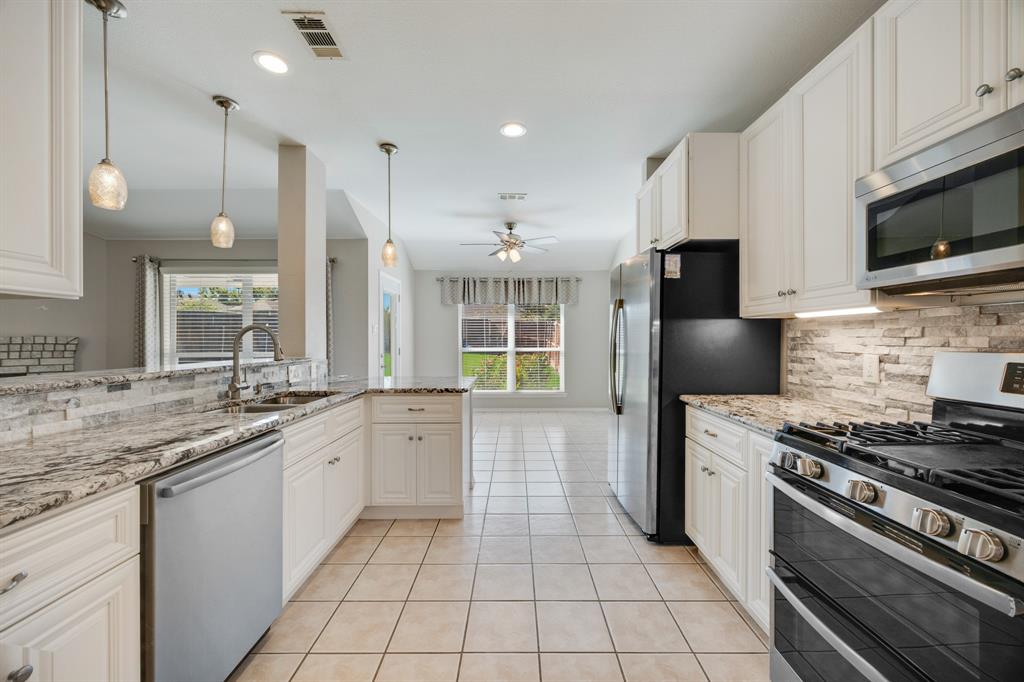 2271 Fieldcrest Drive Rockwall, TX 75032 - Photo 9 of 24 a kitchen with stainless steel appliances granite countertop a sink and a stove