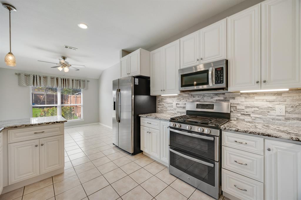 2271 Fieldcrest Drive Rockwall, TX 75032 - Photo 10 of 24 a kitchen with white cabinets and stainless steel appliances