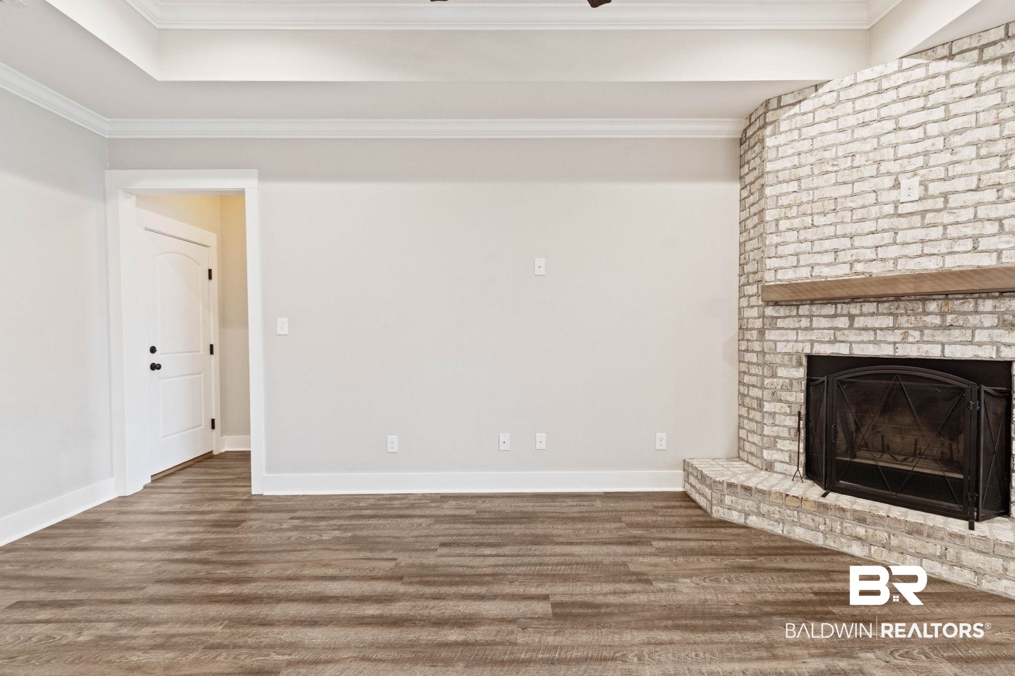 17376 Bankhead Boulevard Fairhope, AL 36532 - Photo 18 of 73 Unfurnished living room featuring ornamental molding, wood finished floors, and a fireplace
