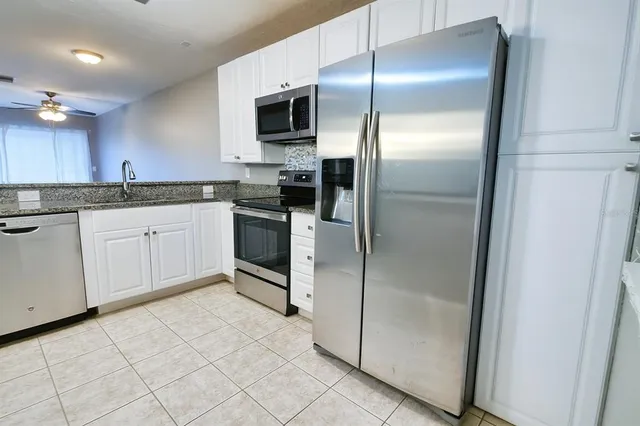 a kitchen with granite countertop a refrigerator and a sink