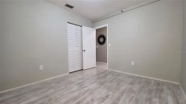 a view of a room with wooden floor and a window