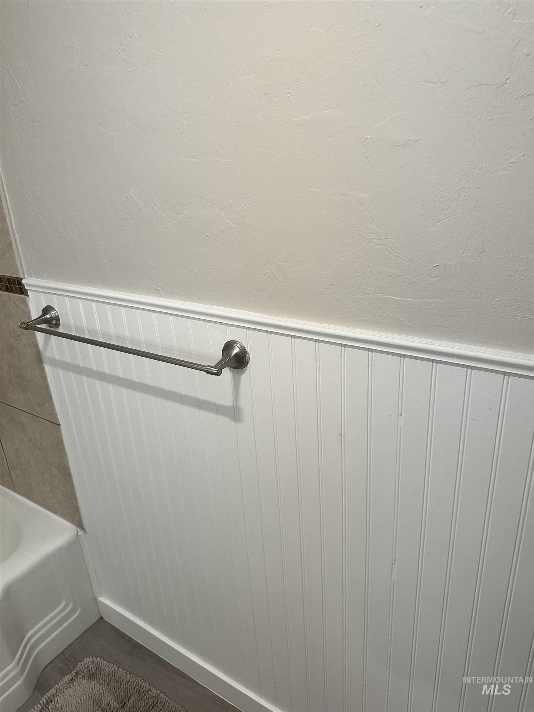 661 Southwest 3rd Street Ontario, OR 97914 - Photo 12 of 45 Bathroom view of a wainscoted wall, a bathtub, and a textured wall
