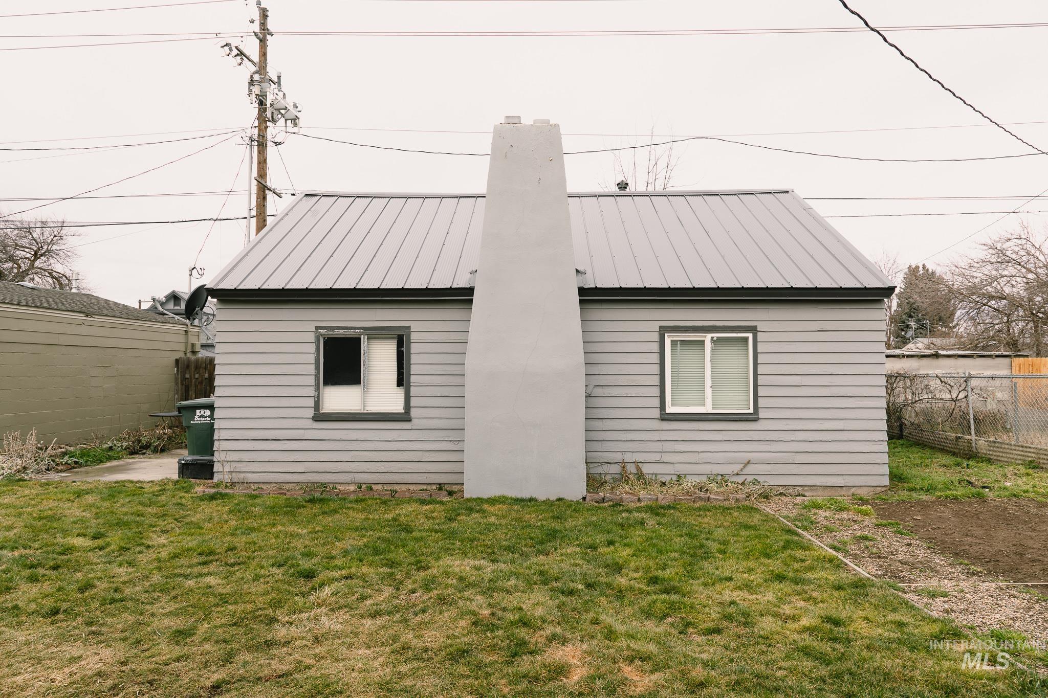 661 Southwest 3rd Street Ontario, OR 97914 - Photo 32 of 45 Rear view of house with a metal roof and a chimney