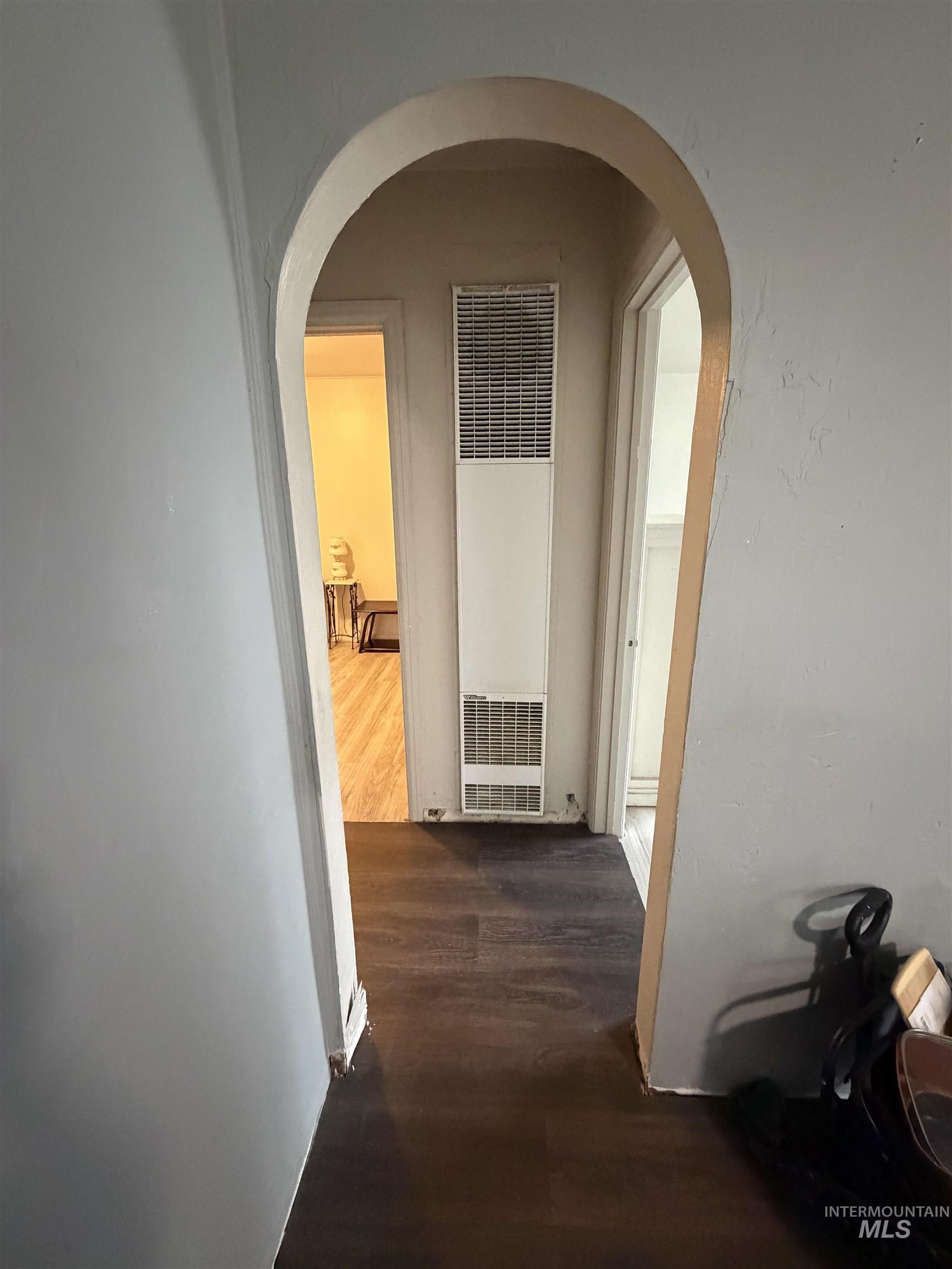 661 Southwest 3rd Street Ontario, OR 97914 - Photo 36 of 45 Corridor with dark wood-style floors, a heating unit, and arched walkways