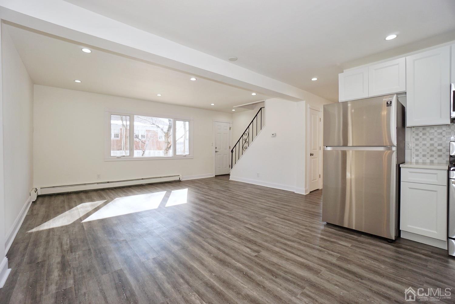 106 Ridge Road Colonia, NJ 07067 - Photo 11 of 44 a view of an empty room with wooden floor and a refrigerator