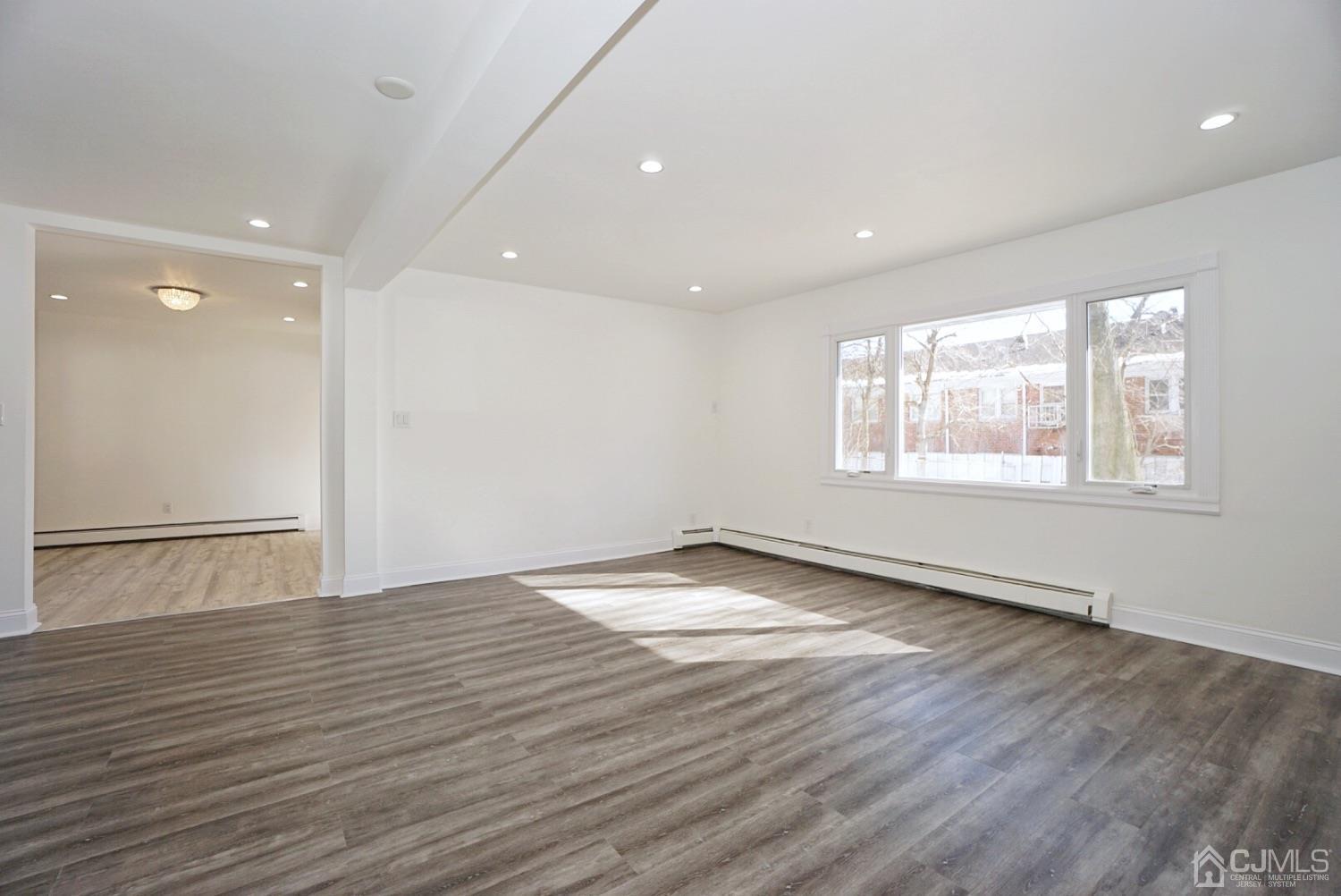 106 Ridge Road Colonia, NJ 07067 - Photo 12 of 44 an empty room with wooden floor and windows