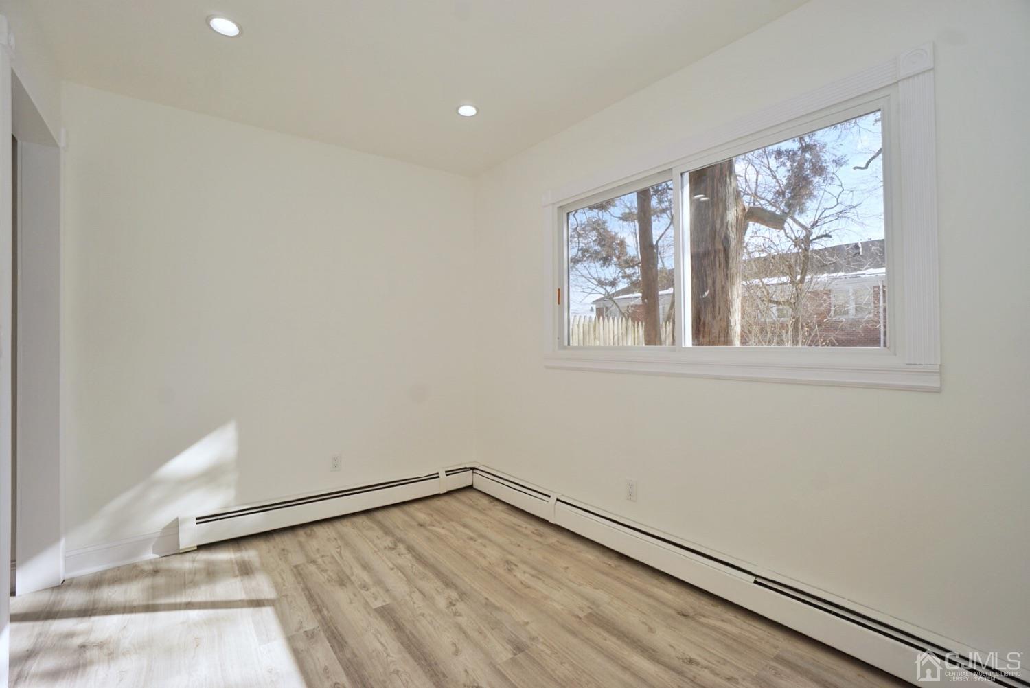 106 Ridge Road Colonia, NJ 07067 - Photo 16 of 44 an empty room with wooden floor and windows