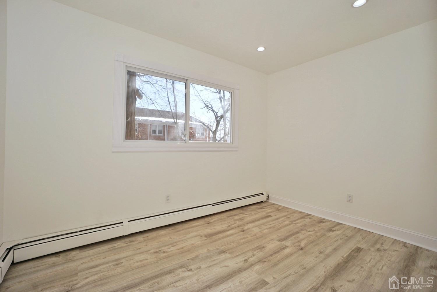 106 Ridge Road Colonia, NJ 07067 - Photo 17 of 44 an empty room with wooden floor and windows