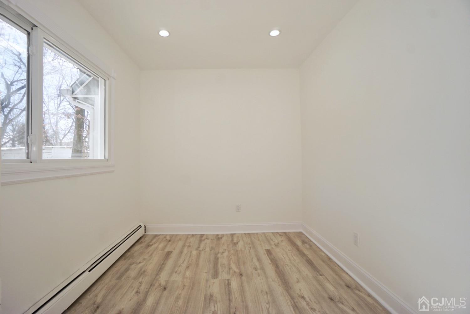 106 Ridge Road Colonia, NJ 07067 - Photo 19 of 44 a view of an empty room with wooden floor and a window