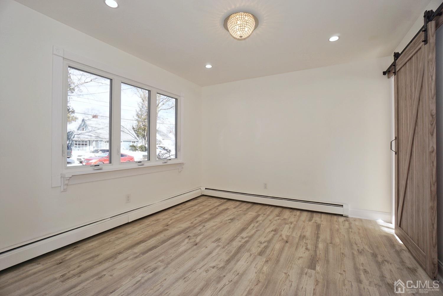 106 Ridge Road Colonia, NJ 07067 - Photo 21 of 44 an empty room with wooden floor and windows