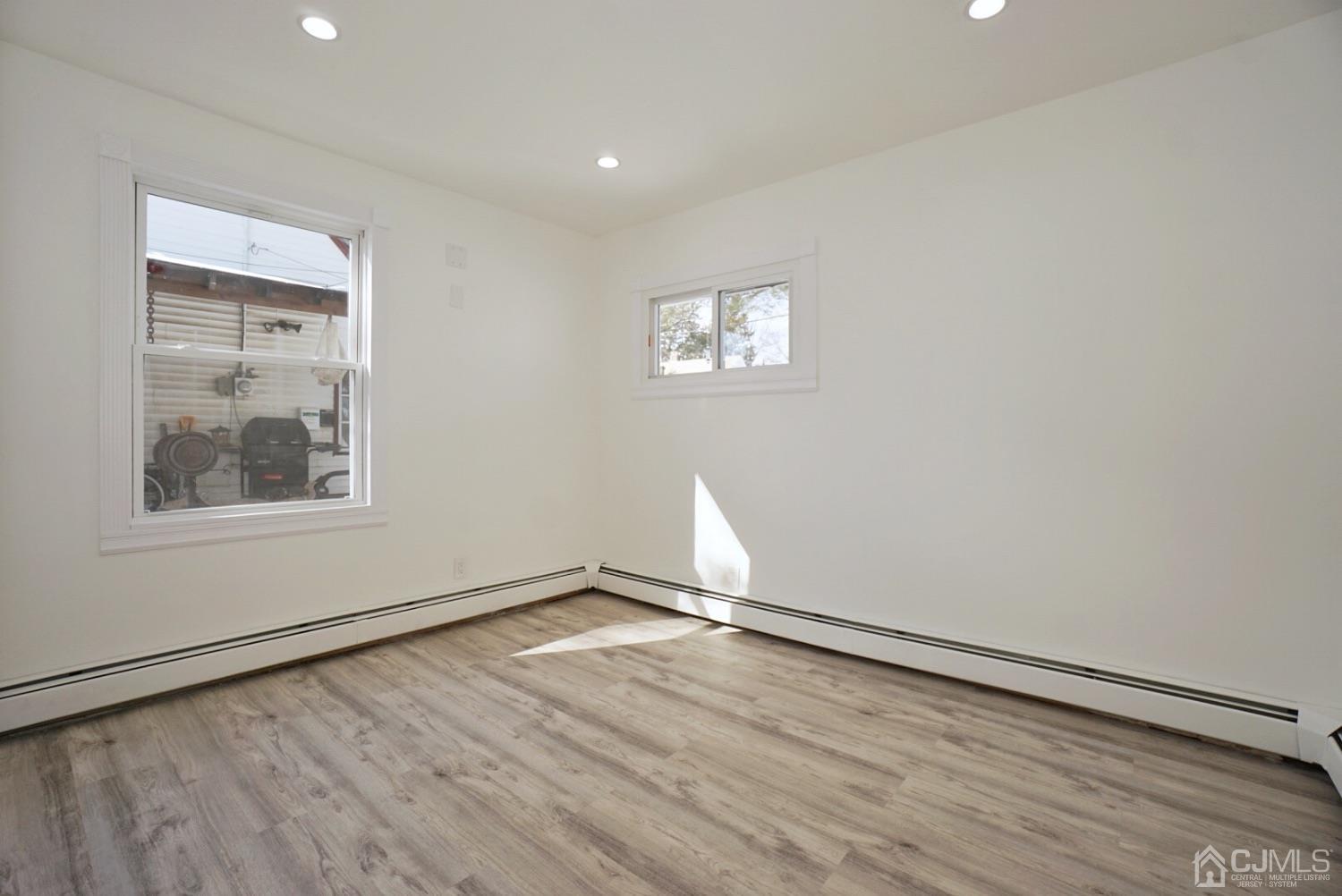 106 Ridge Road Colonia, NJ 07067 - Photo 26 of 44 an empty room with wooden floor and windows