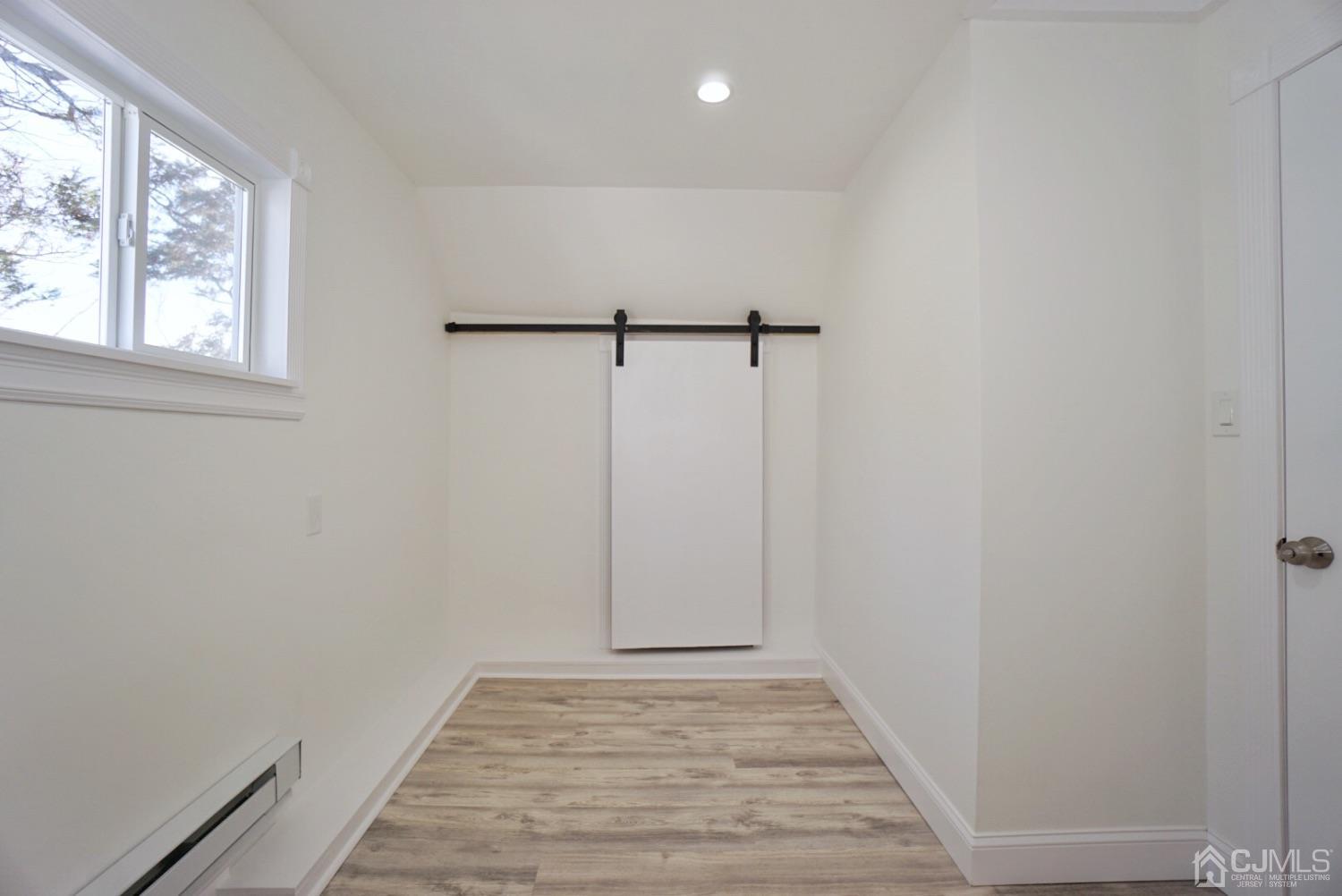 106 Ridge Road Colonia, NJ 07067 - Photo 31 of 44 a view of an empty room with window and hardwood floor