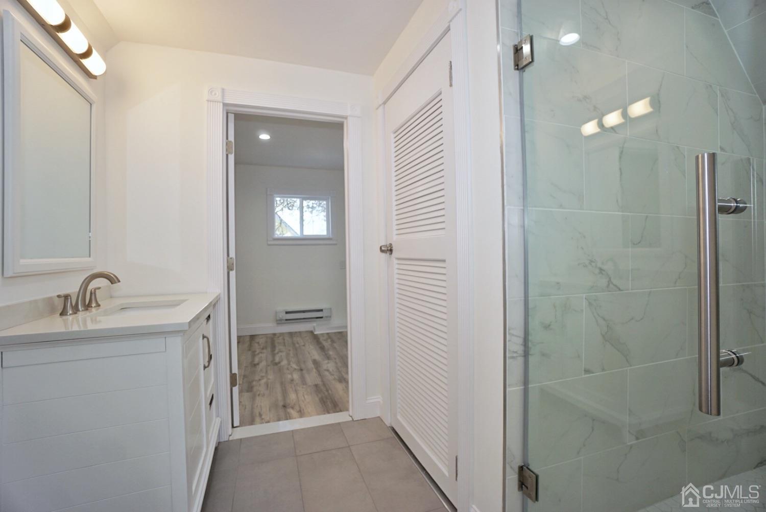 106 Ridge Road Colonia, NJ 07067 - Photo 36 of 44 a bathroom with a granite countertop sink a shower and a mirror