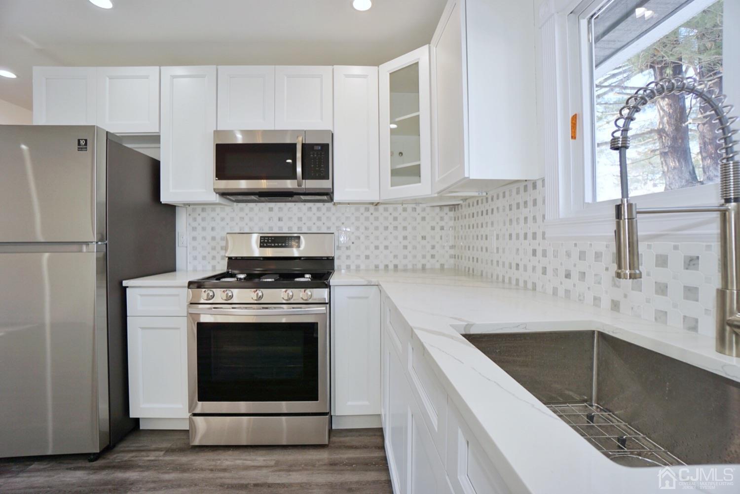 106 Ridge Road Colonia, NJ 07067 - Photo 5 of 44 a kitchen with stainless steel appliances granite countertop a sink stove and microwave
