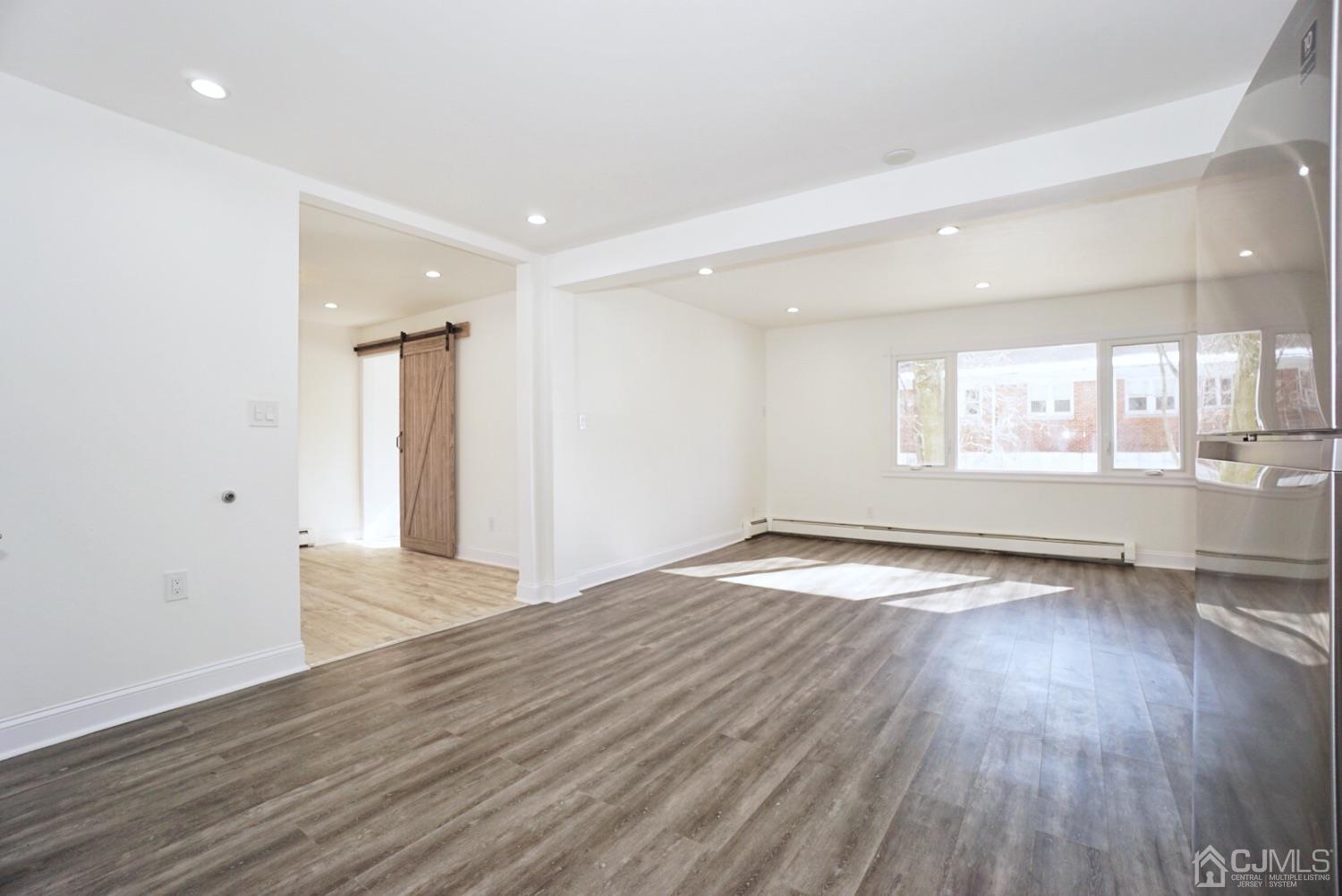 106 Ridge Road Colonia, NJ 07067 - Photo 6 of 44 an empty room with wooden floor and windows