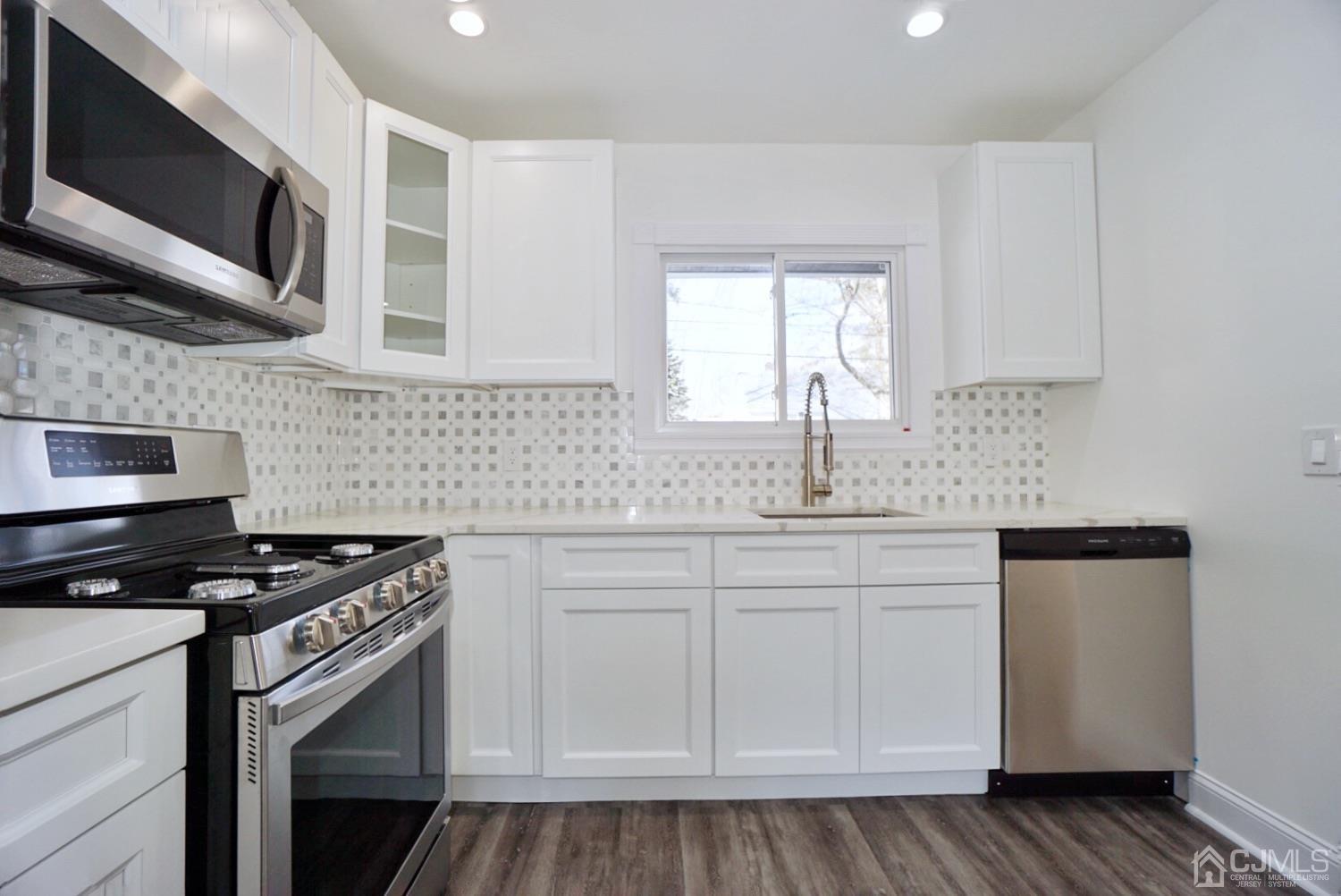 106 Ridge Road Colonia, NJ 07067 - Photo 7 of 44 a kitchen with stainless steel appliances a sink stove and microwave