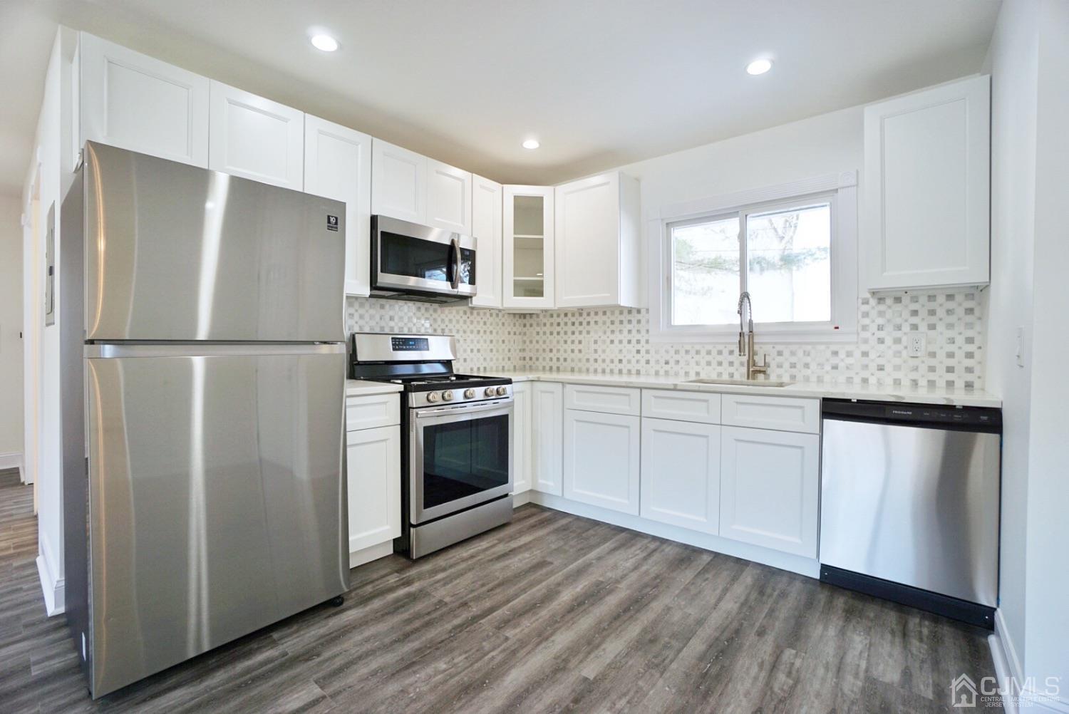 106 Ridge Road Colonia, NJ 07067 - Photo 8 of 44 a kitchen with stainless steel appliances a refrigerator sink and microwave