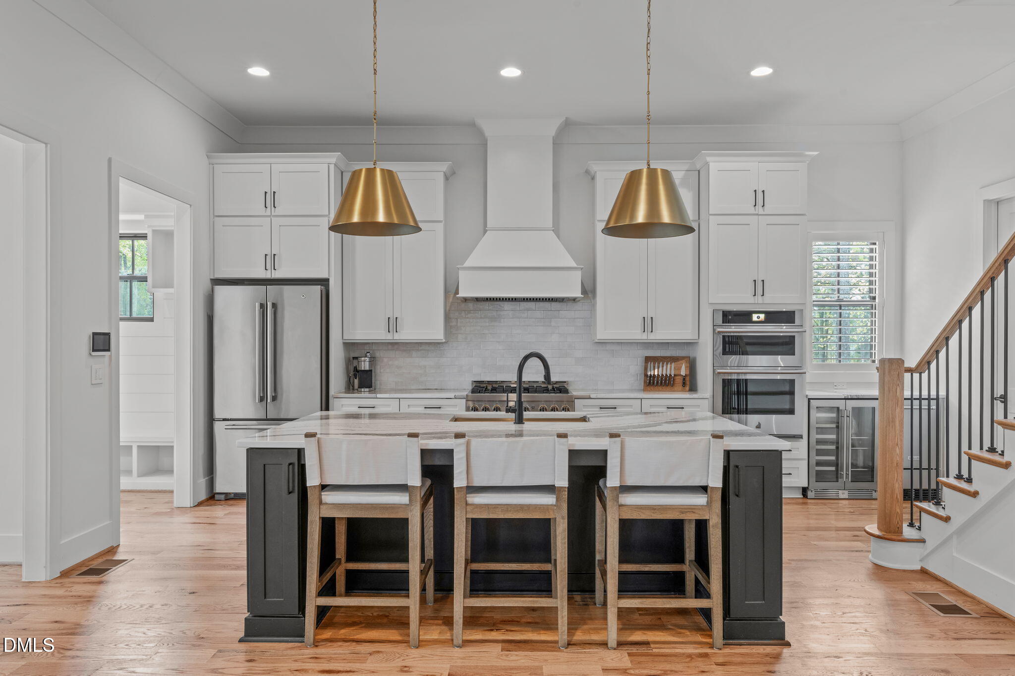 5005 Ten-Ten Road Apex, NC 27539 - Photo 10 of 60 Stainless steel appliances, wall ovens, vent hood, bar area to the right, mud room to the left.