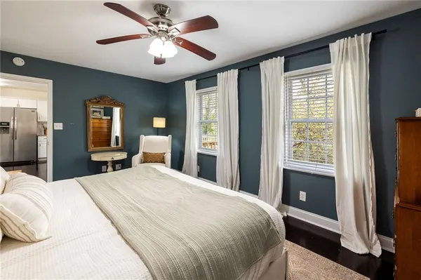 a bedroom with a large bed and a chandelier fan