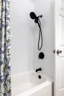 a bathroom with a bath tub with a shower