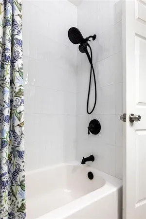 a bathroom with a bath tub with a shower
