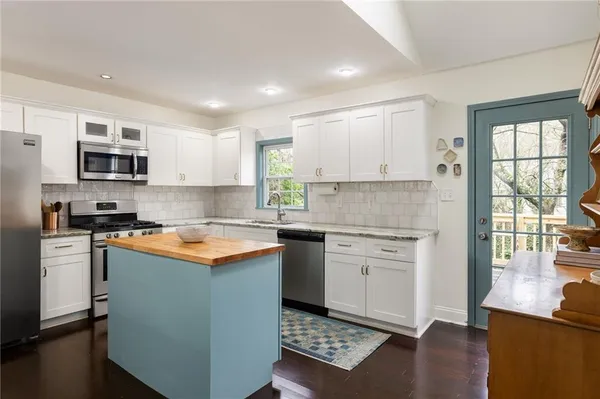 a kitchen with stainless steel appliances granite countertop a stove a sink and a microwave