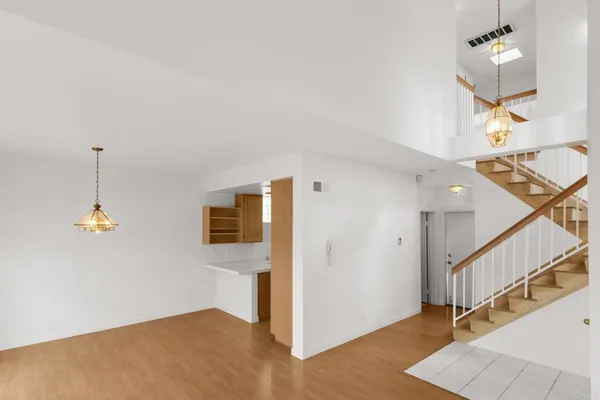 a dining room with wooden floor a chandelier a wooden table and chairs