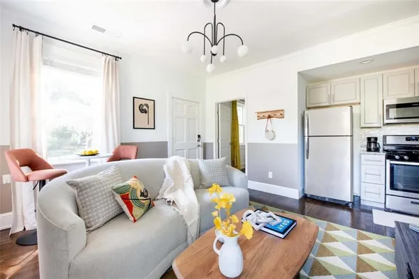 a living room with furniture and a refrigerator