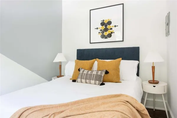 a bedroom with a bed and a painting on the wall