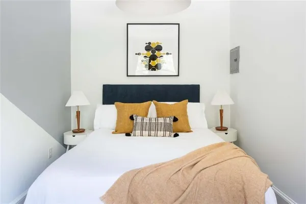 a bed sitting in a bedroom next to a lamp